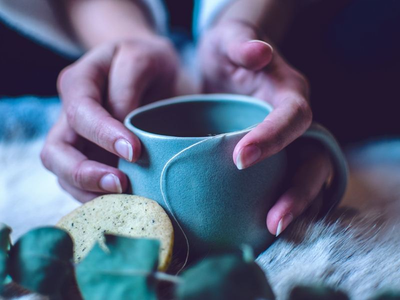 Two hands cradling a warm cup