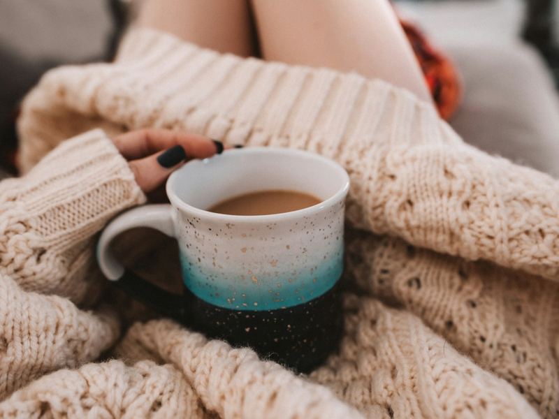 A mug of tea held in a knitted blanket