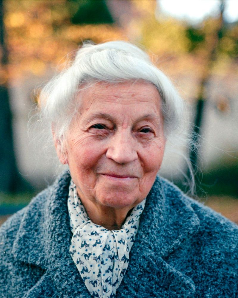An older woman smiling in an autumn garden